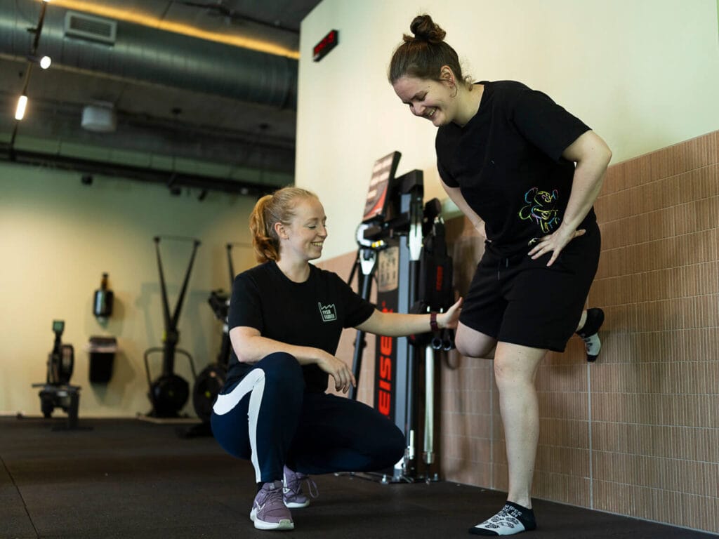 Fysio traint met patient in praktijkruimte